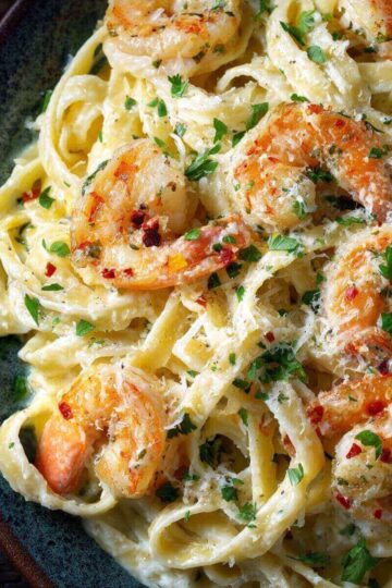 Creamy 30 Minute Shrimp Alfredo in a skillet, topped with seared shrimp and parsley, ready to serve.
