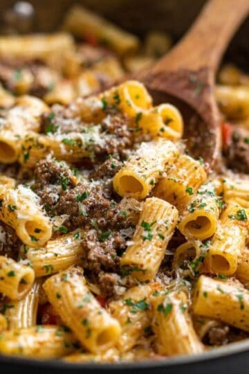 one pot creamy beef and garlic butter pasta topped with parsley and parmesan in a skillet