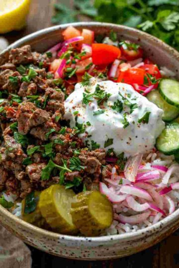 Beef shawarma bowl with spiced ground beef, rice, vegetables, and garlic yogurt sauce