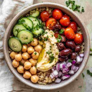 Mediterranean grain bowl with quinoa, chickpeas, vegetables, olives, and lemon dressing