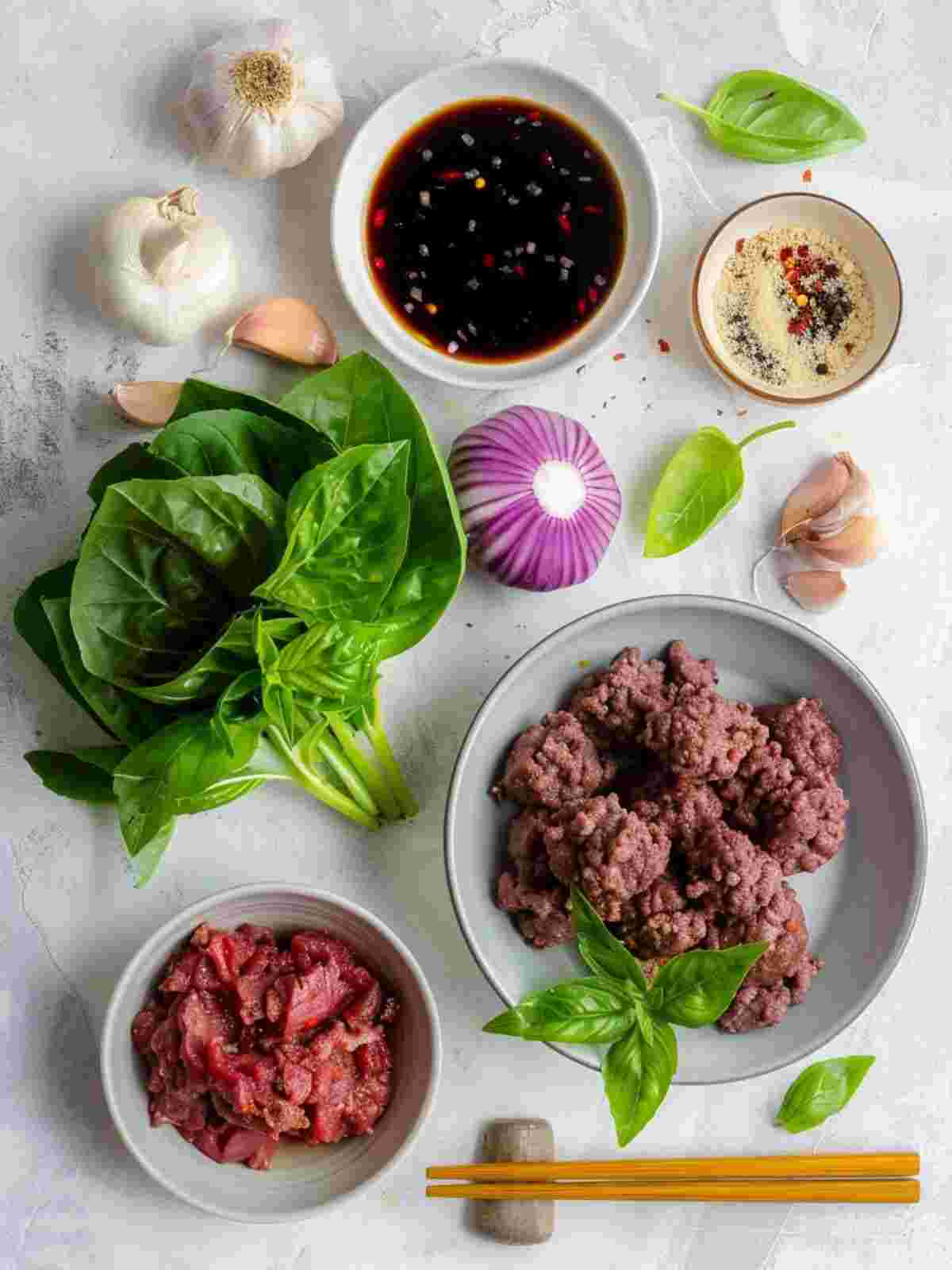 Ingredients for thai basil beef rolls including ground beef Thai basil lettuce garlic chili and lime