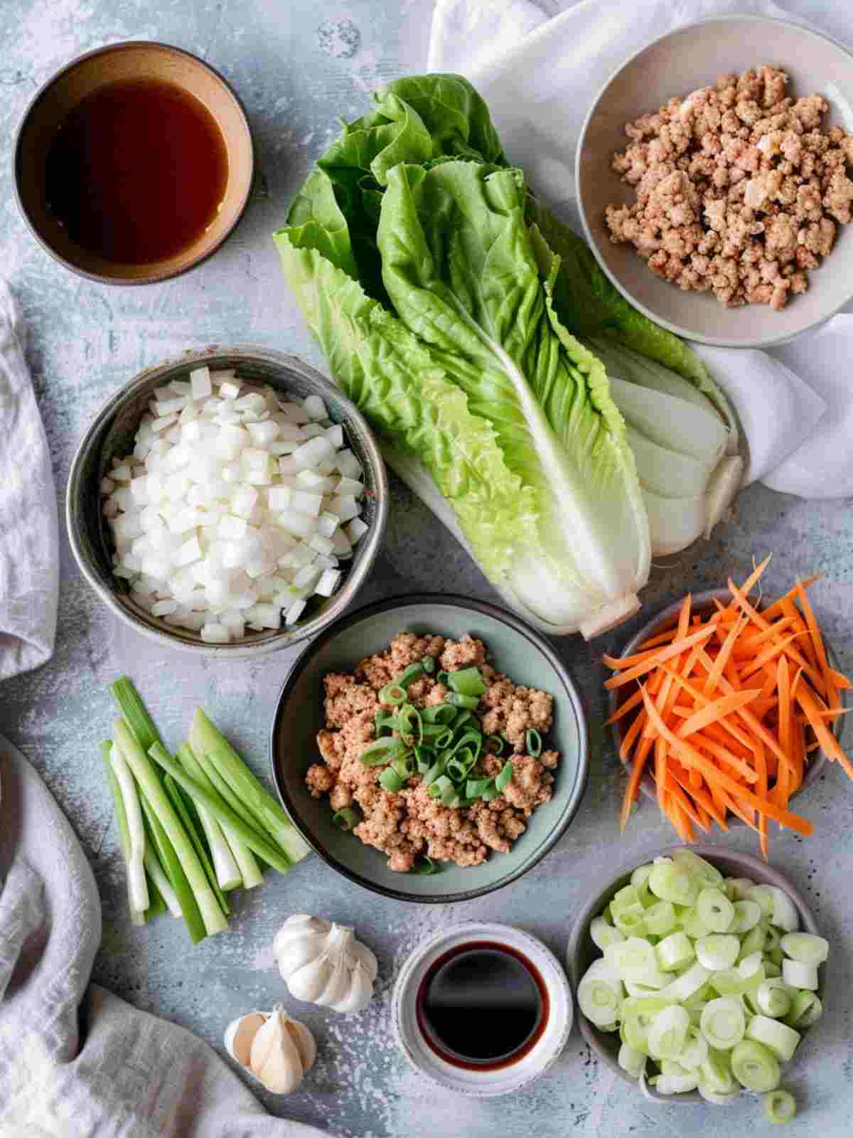 Chicken Lettuce Wraps 1 Ingredients for chicken lettuce wraps including ground chicken, lettuce, garlic, ginger, carrots, green onions, water chestnuts, and sauces